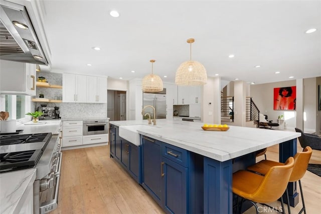 31852 Via Faisan, Coto De Caza, CA 92679 - kitchen featuring high quality appliances, a sink, exhaust hood, blue cabinets, and white cabinets