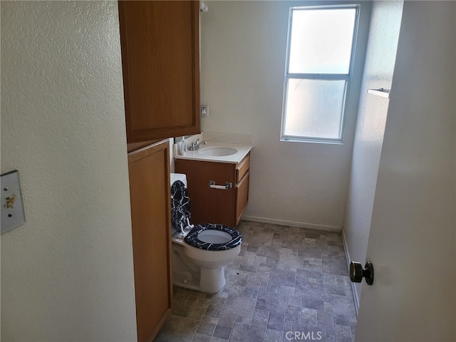 1616 Bluebell St, Lancaster, CA 93535 - bathroom with vanity, toilet, baseboards, and stone finish flooring