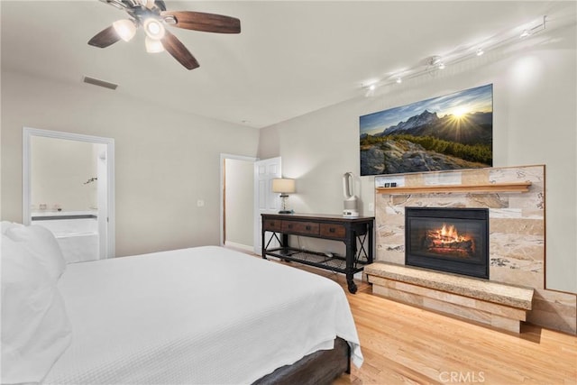 1271 N Tulare Way, Upland, CA 91786 - bedroom featuring wood finished floors, a glass covered fireplace, ensuite bathroom, and ceiling fan
