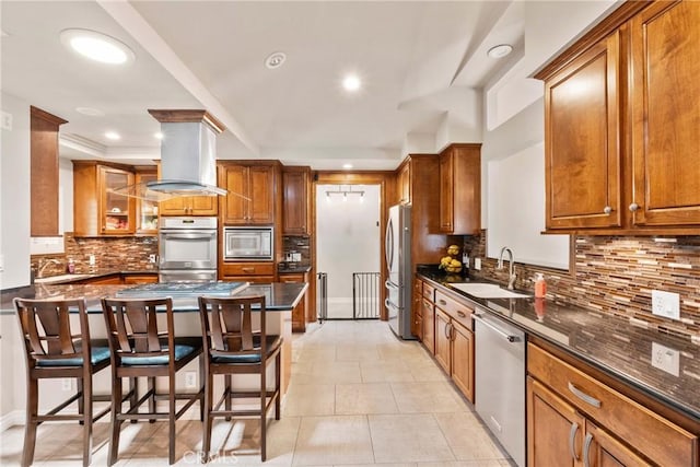 1271 N Tulare Way, Upland, CA 91786 - kitchen with stainless steel appliances, a sink, a breakfast bar, decorative backsplash, and brown cabinets