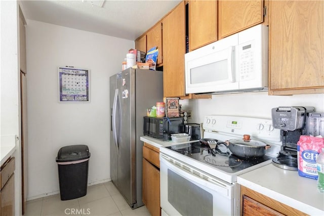 2142 S Mountain Ave, Ontario, CA 91762 - kitchen with white appliances, light countertops, brown cabinetry, and light tile patterned flooring