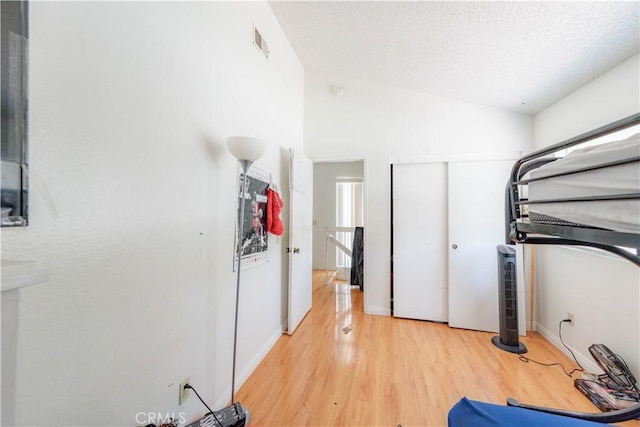 2142 S Mountain Ave, Ontario, CA 91762 - exercise room with light wood-style floors, a textured ceiling, and vaulted ceiling