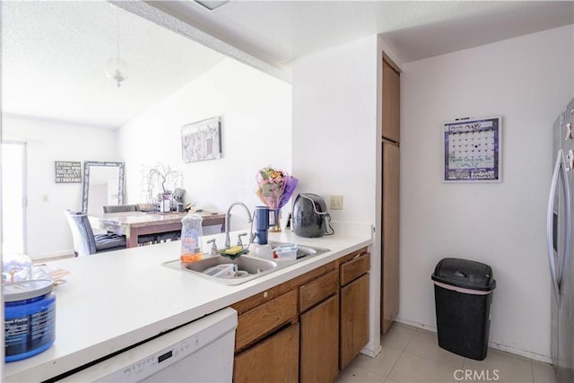 2142 S Mountain Ave, Ontario, CA 91762 - kitchen featuring a sink, light countertops, white dishwasher, light tile patterned flooring, and brown cabinets