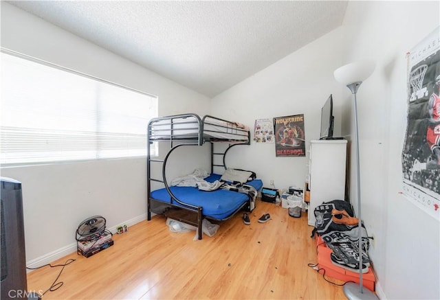2142 S Mountain Ave, Ontario, CA 91762 - bedroom with wood finished floors, vaulted ceiling, a textured ceiling, and baseboards