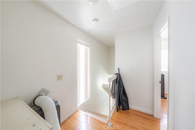 2142 S Mountain Ave, Ontario, CA 91762 - corridor featuring light wood-style floors, an upstairs landing, a textured ceiling, plenty of natural light, and baseboards