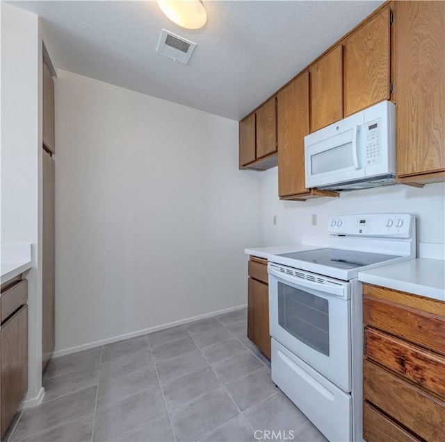 2142 S Mountain Ave, Ontario, CA 91762 - kitchen with white appliances, brown cabinetry, light countertops, and light tile patterned floors