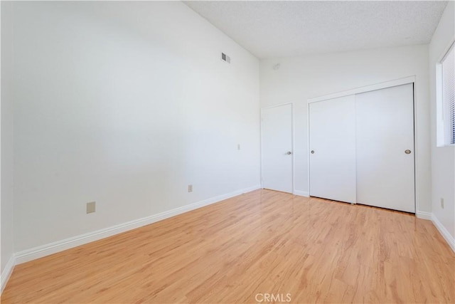 2142 S Mountain Ave, Ontario, CA 91762 - unfurnished bedroom featuring light wood finished floors, a closet, a textured ceiling, and vaulted ceiling