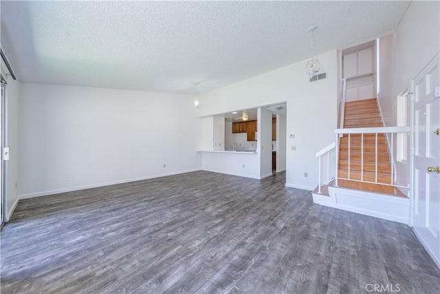 2142 S Mountain Ave, Ontario, CA 91762 - unfurnished living room featuring a textured ceiling, stairway, and dark wood finished floors