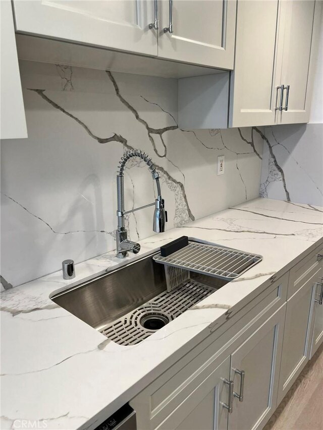 900 Euclid St Unit 307, Santa Monica, CA 90403 - kitchen with a sink, tasteful backsplash, light stone countertops, and light wood-style floors