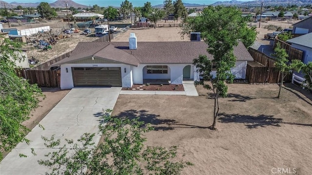 21918 Mohican Ave, Apple Valley, CA 92307 - ranch-style home with a mountain view, a garage, concrete driveway, a shingled roof, and stucco siding