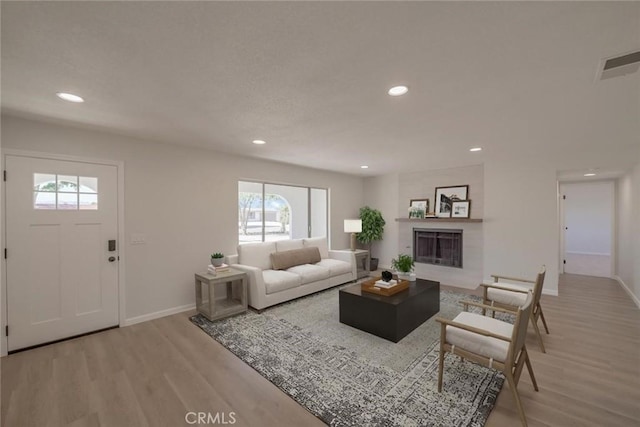 21918 Mohican Ave, Apple Valley, CA 92307 - living room featuring light wood-type flooring, recessed lighting, and a tile fireplace