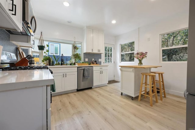 425961 Maryland St, San Diego, CA 92103 - kitchen featuring stainless steel appliances, a sink, white cabinets, light wood finished floors, and recessed lighting