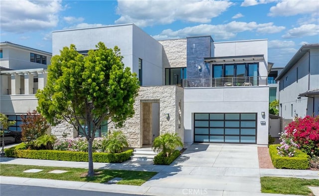 59 Dorado, Irvine, CA 92618 - contemporary house featuring a balcony, stone siding, driveway, an attached garage, and stucco siding
