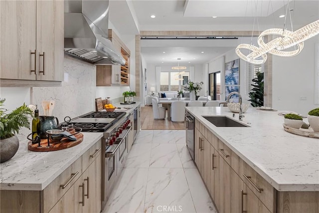 59 Dorado, Irvine, CA 92618 - kitchen featuring wall chimney exhaust hood, a sink, appliances with stainless steel finishes, light brown cabinets, and a chandelier