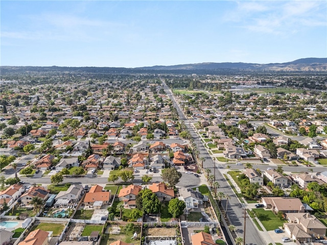 aerial view of property and surrounding area with a mountain backdrop and nearby suburban area