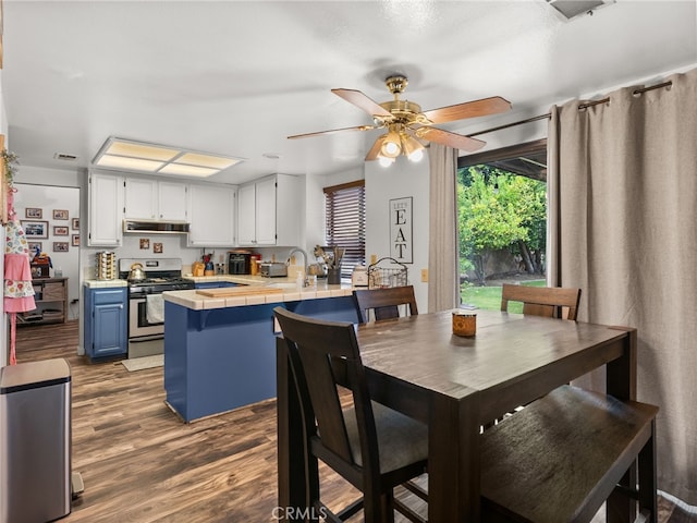 dining space featuring a ceiling fan and dark wood-style flooring