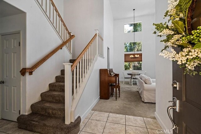 28335 Arroyo Ct, Castaic, CA 91384 - entryway featuring light carpet, stairs, a towering ceiling, a chandelier, and healthy amount of natural light