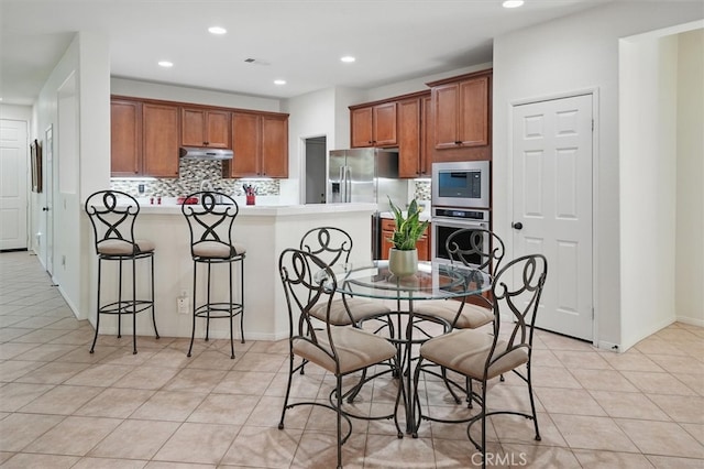 29661 Cambridge Ave, Castaic, CA 91384 - kitchen with stainless steel appliances, under cabinet range hood, a peninsula, brown cabinetry, and recessed lighting