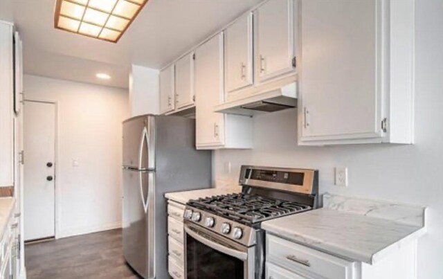 4591 Orange Ave Unit 306, Long Beach, CA 90807 - kitchen featuring appliances with stainless steel finishes, under cabinet range hood, light countertops, wood finished floors, and white cabinets
