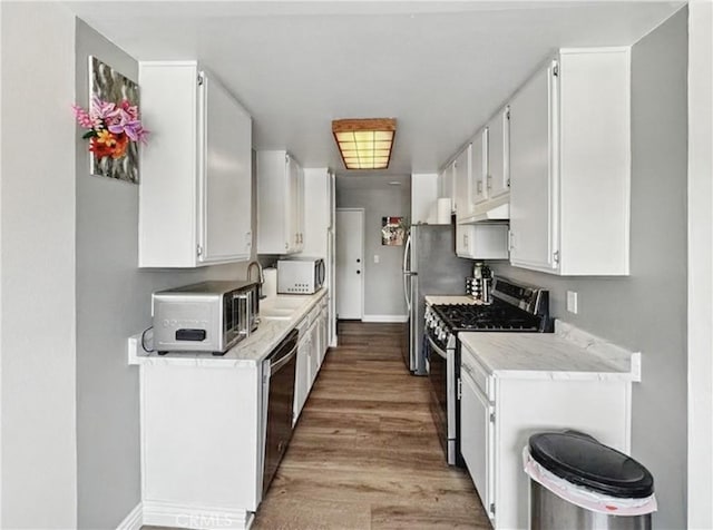 4591 Orange Ave Unit 306, Long Beach, CA 90807 - kitchen with appliances with stainless steel finishes, baseboards, white cabinets, and light countertops