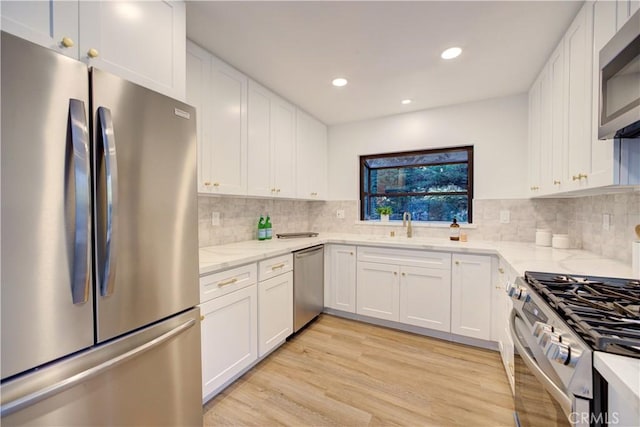 953 Sheffield St, Cambria, CA 93428 - kitchen with stainless steel appliances, light stone countertops, white cabinets, light wood-style flooring, and recessed lighting