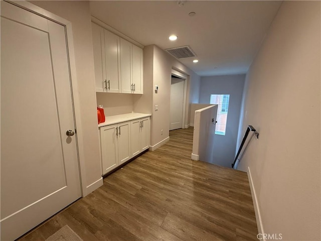hall featuring an upstairs landing, dark wood-style floors, recessed lighting, and baseboards