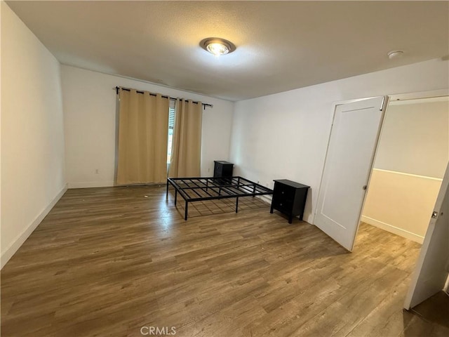 unfurnished bedroom featuring wood finished floors and baseboards