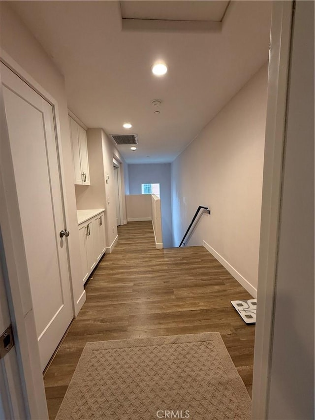 corridor with an upstairs landing, baseboards, recessed lighting, and dark wood finished floors