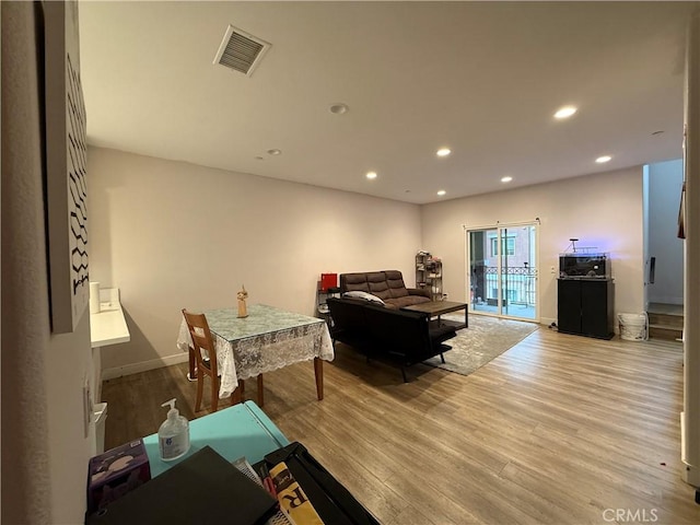 living room featuring light wood-type flooring, recessed lighting, and baseboards