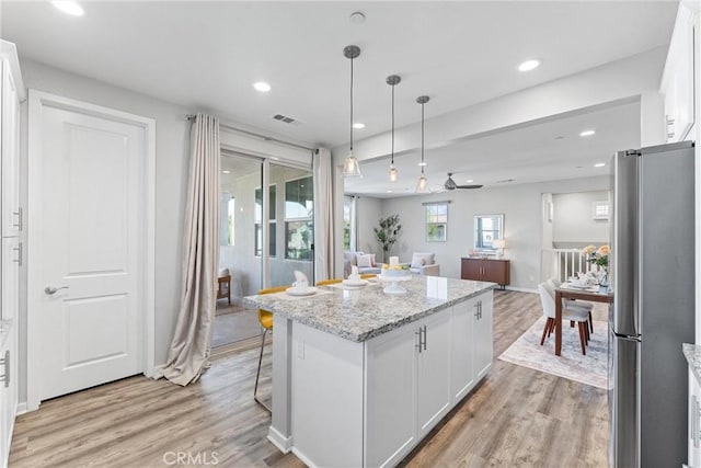 kitchen with freestanding refrigerator, light wood finished floors, white cabinetry, open floor plan, and recessed lighting