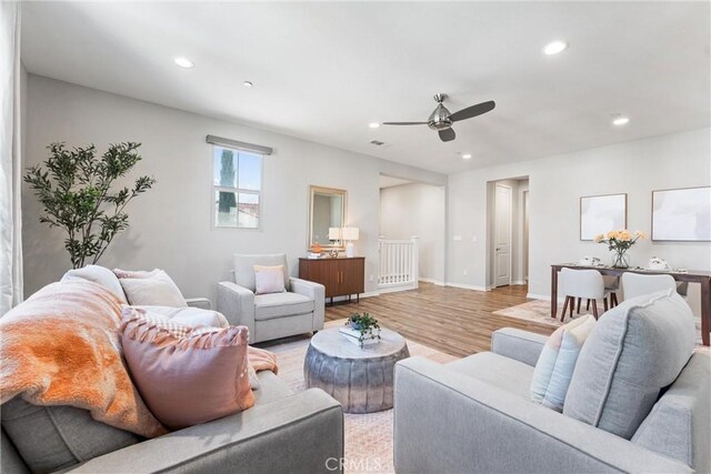 living room with ceiling fan, light wood-type flooring, recessed lighting, and baseboards