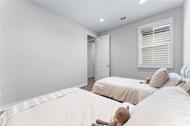 bedroom with wood finished floors, recessed lighting, and baseboards