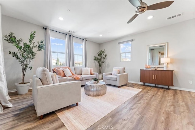living room featuring wood finished floors, a ceiling fan, baseboards, and recessed lighting