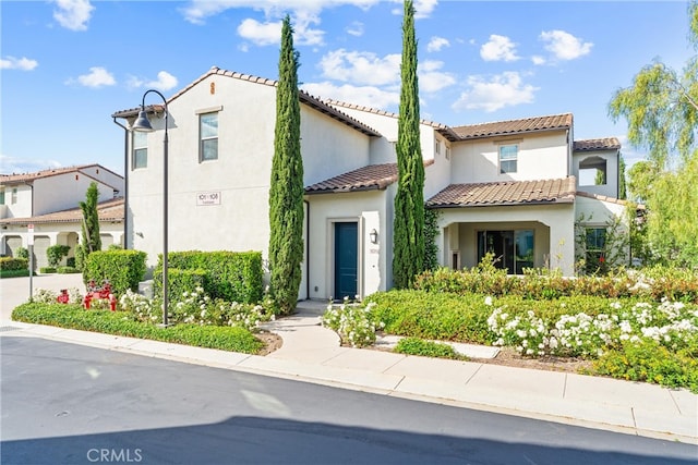 mediterranean / spanish-style home with a tile roof and stucco siding