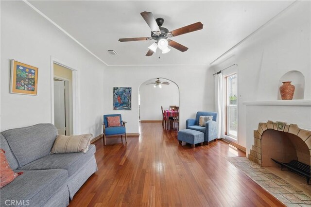 832 S 7th St, Alhambra, CA 91801 - living area featuring a ceiling fan, a fireplace, wood-type flooring, arched walkways, and baseboards