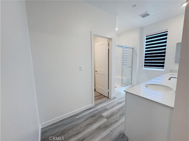 3661 S Allston Paseo Unit 7, Ontario, CA 91761 - full bath with wood finished floors, a shower stall, double vanity, and baseboards