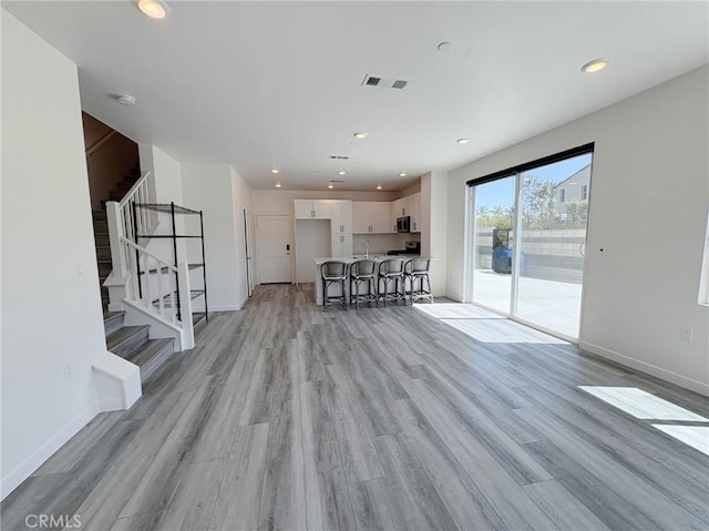 3661 S Allston Paseo Unit 7, Ontario, CA 91761 - living area featuring light wood finished floors, stairs, baseboards, and recessed lighting