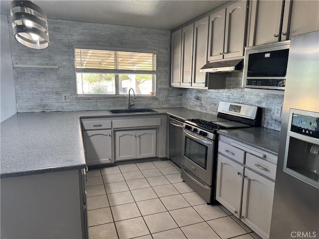 8723 Palomar Ave, Yucca Valley, CA 92284 - kitchen featuring appliances with stainless steel finishes, under cabinet range hood, a sink, light tile patterned floors, and backsplash