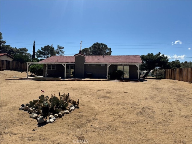 8723 Palomar Ave, Yucca Valley, CA 92284 - back of property featuring a tile roof, fence, and stucco siding