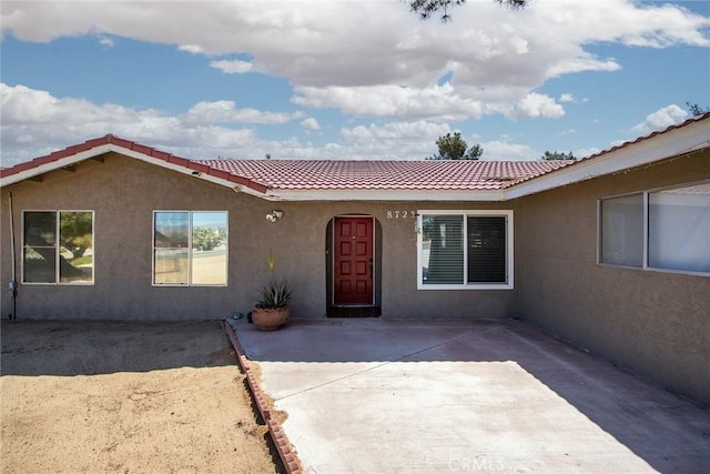 8723 Palomar Ave, Yucca Valley, CA 92284 - view of front facade featuring stucco siding, a tile roof, and a patio