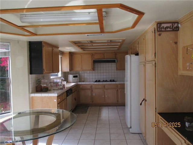 kitchen with tile countertops, tasteful backsplash, freestanding refrigerator, dishwasher, and light tile patterned floors