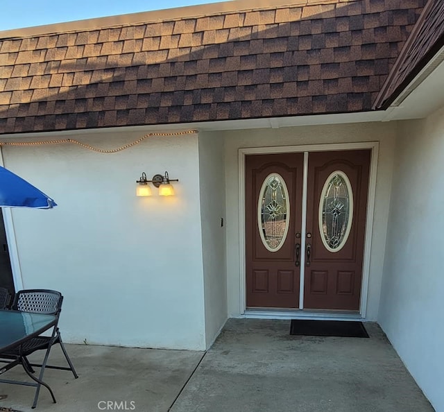 25813 Sandy Lodge Rd, Menifee, CA 92586 - doorway to property with a shingled roof and stucco siding