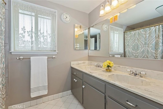 bathroom featuring double vanity, baseboards, and tile patterned floors