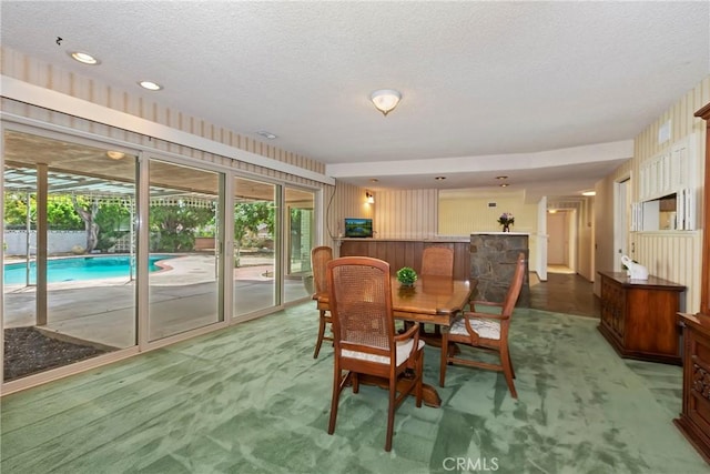 carpeted dining room with a textured ceiling and recessed lighting