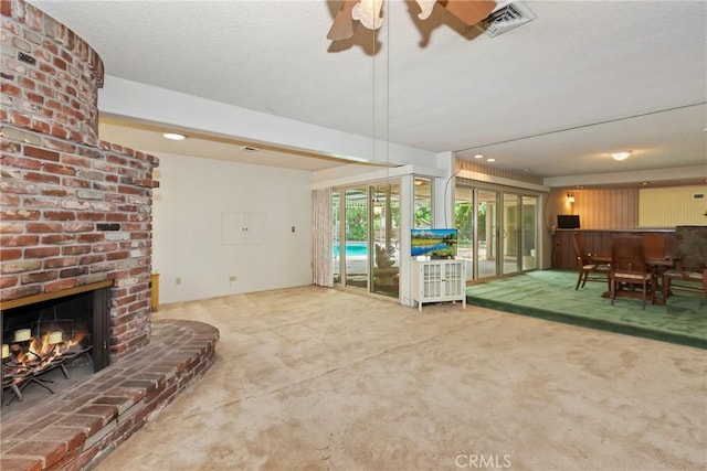 carpeted living room featuring a ceiling fan, a brick fireplace, a textured ceiling, and recessed lighting