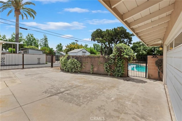 view of patio with fence, a gate, and an outdoor structure
