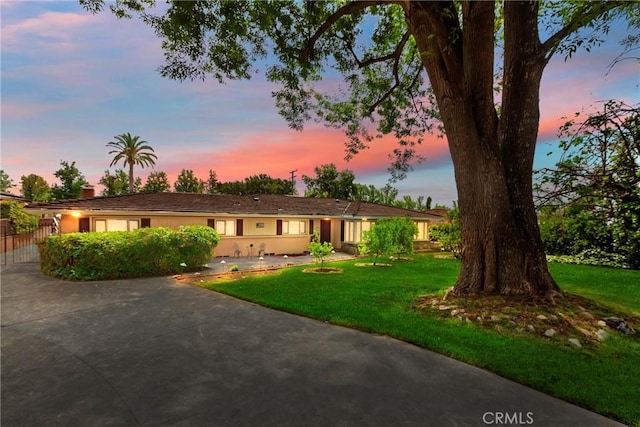 single story home with a yard and concrete driveway