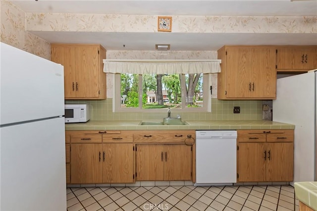 kitchen with white appliances, a sink, and decorative backsplash