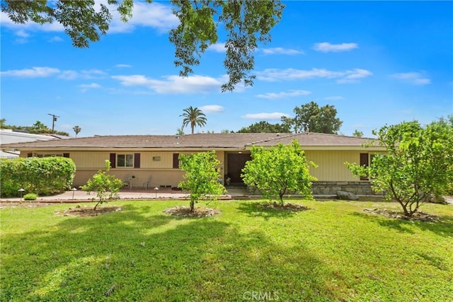 rear view of property featuring a patio area and a lawn