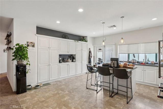 2921 Gibson St, Riverside, CA 92503 - kitchen featuring recessed lighting, white cabinets, a breakfast bar area, hanging light fixtures, and a kitchen island